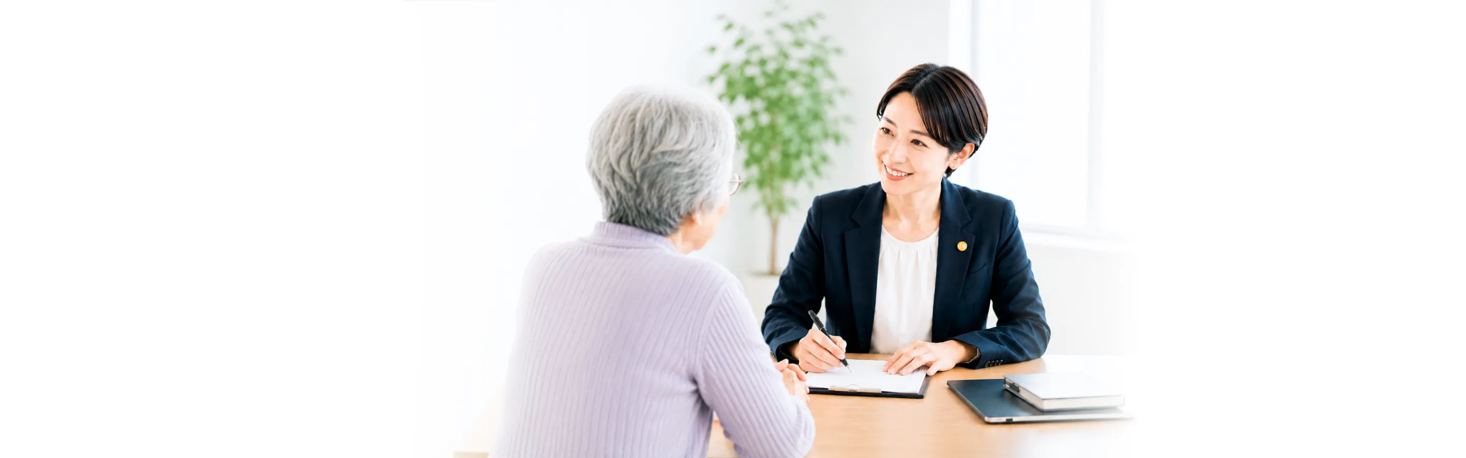 相談にのる弁護士とシニア女性の背景